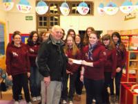 Lion Ron presenting the cheque to the Ottery Guides in their Hoodies